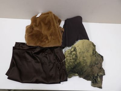 un ours en peluche posé sur une table, à côté d'autres vêtements