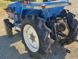 a blue tractor that is parked on the side of the road