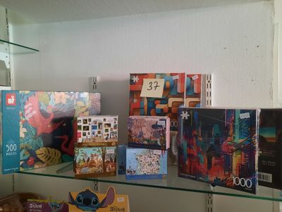 une étagère en verre sur laquelle sont posés des livres, dans une pièce