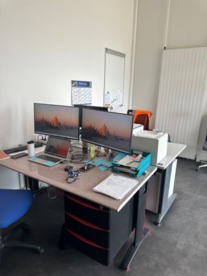un bureau avec deux ordinateurs et une chaise dans la chambre