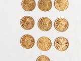 a close up of a bunch of gold coins on a white surface