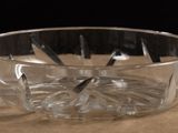 a clear glass bowl on a table with a knife in it