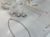 many necklaces and bracelets on display in a glass case