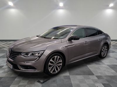 Une voiture grise est garée dans une pièce au sol carrelé en damier.