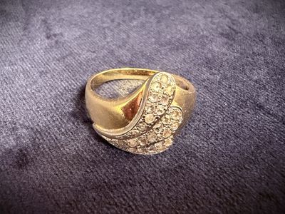 an image of a gold ring sitting on top of a purple cloth