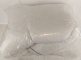 two pillows that are wrapped in plastic on the floor