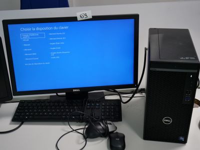 un ordinateur de bureau posé sur une table à côté d'un clavier et d'une souris