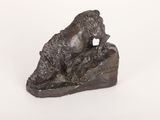 statue en bronze représentant un ours posé sur un rocher, sur fond blanc