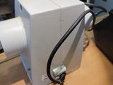 un petit objet blanc sur une table à côté d'une paire de ciseaux