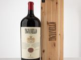 a bottle of wine sitting next to a wooden box on a table