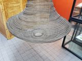 a wicker lamp hanging from the ceiling in a store