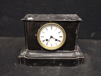 une petite horloge posée sur une table noire