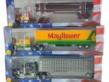 Trois camions miniatures sont empilés les uns sur les autres dans une vitrine.