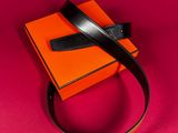 an orange box with a black leather belt on top of it
