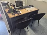 a desk with two chairs and a laptop on it