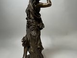 bronze statue of a woman holding a bird in her hand