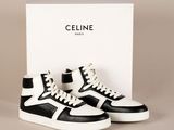 une paire de baskets noires et blanches devant une boîte blanche