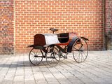 a small toy horse and carriage on a brick floor