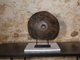 un grand objet métallique posé sur une table devant un mur de pierre