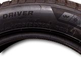 a tire that is on the side of a white wall