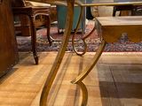 a table with a glass top sitting on a wooden floor