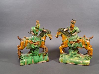 pair of chinese figurines of men on horses and a man on a horse