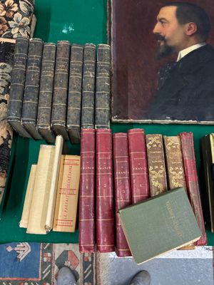beaucoup de livres posés sur une table, avec la photo d'un homme