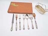 une boîte contenant des couverts et un panier contenant des couverts posés sur une table