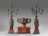three bronze - plated candlesticks and a vase on a stand