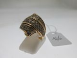 gros plan d'une bague sur une surface blanche avec une étiquette de prix