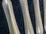 six silverwares are lined up in a row on a table