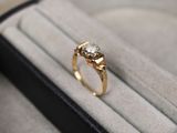 une bague en or sertie d'un diamant, dans un écrin