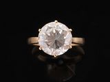 an engagement ring with a white diamond on a black background