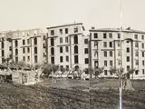 a black and white photo of a large building in the middle of a field