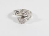 a close up of a diamond ring on a white surface