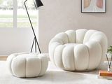 une photo d'un salon avec un fauteuil blanc et un pouf