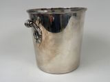 a silver cup with a leaf on it on a table
