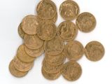 une pile de pièces d'or posée sur une surface blanche