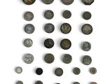 an assortment of ancient coins on a white surface