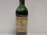 une vieille bouteille de vin posée sur une table blanche