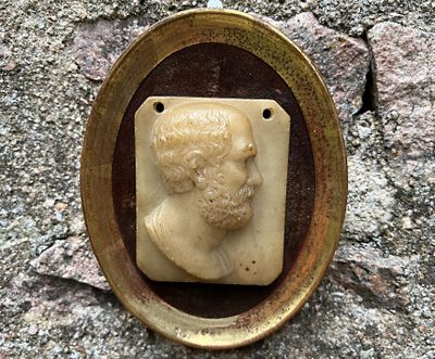 une photo d'une photo représentant le buste d'un homme sur un mur de pierre