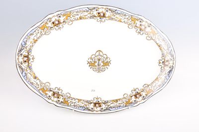 un plat ovale orné d'un motif doré et blanc