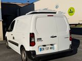 une camionnette blanche garée sur un parking à côté d'un bâtiment