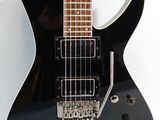 an electric guitar with a black body sitting on top of a white surface