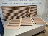 plusieurs lattes de bois empilées les unes sur les autres devant un mur