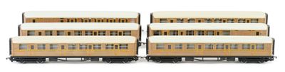 four train cars sitting side by side on a white surface