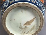 a close up of a vase with a bird on it