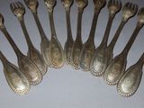 eight silverware spoons are arranged in a row on a table