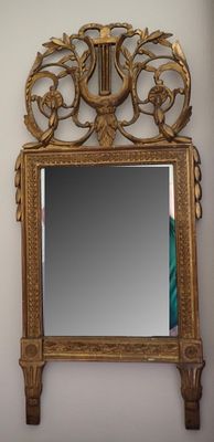 un miroir accroché au mur, avec un cadre doré