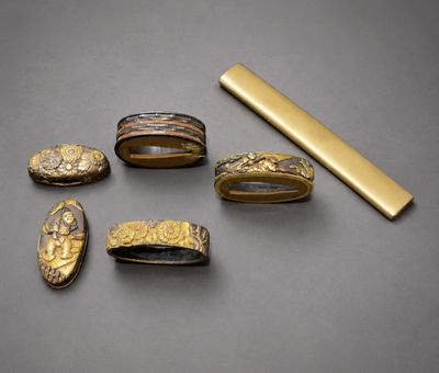 un lot de bagues en or et un lingot d'or posés sur une table